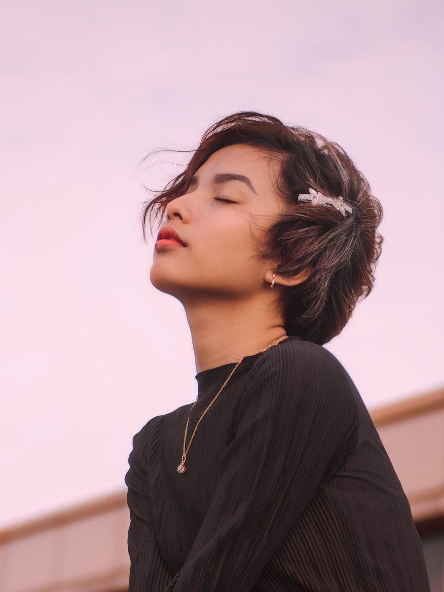 A woman wearing short hair with a side hair accessory.